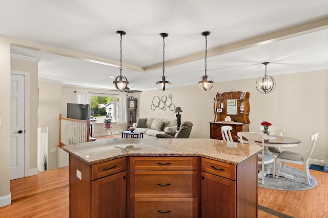 165 Tanglewood Dr, Colchester, VT 05546 - kitchen featuring light wood finished floors, open floor plan, hanging light fixtures, light stone countertops, and ornamental molding