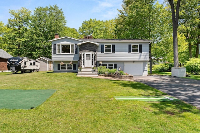 165 Tanglewood Dr, Colchester, VT 05546 - bi-level home featuring a chimney, driveway, a garage, and a front lawn