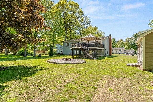 165 Tanglewood Dr, Colchester, VT 05546 - view of grassy yard featuring stairs, a wooden deck, and an outdoor fire pit