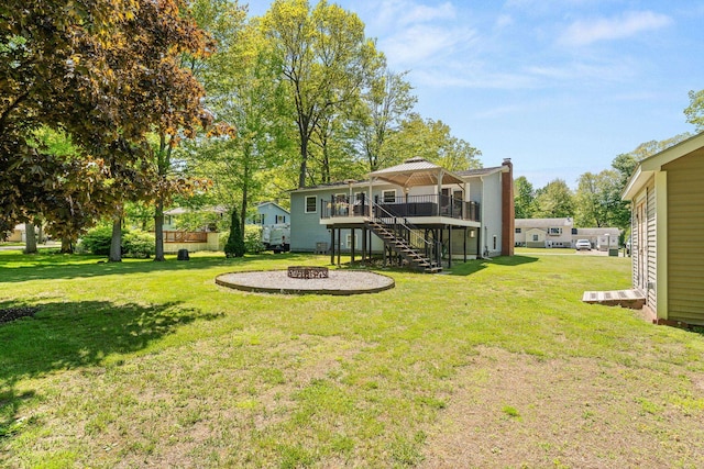 165 Tanglewood Dr, Colchester, VT 05546 - view of grassy yard with stairway, a deck, and an outdoor fire pit