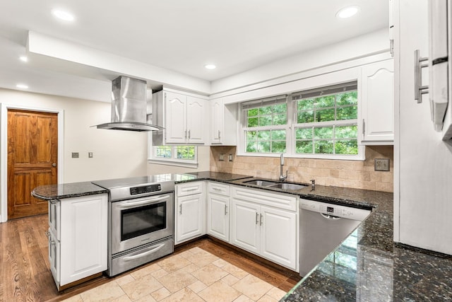 28 Olde Lantern Rd, Bedford, NH 03110 - kitchen featuring exhaust hood, appliances with stainless steel finishes, a sink, a peninsula, and white cabinetry