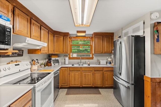 122 Wallace Rd, Northfield, VT 05663 - kitchen featuring stainless steel appliances, a sink, under cabinet range hood, light countertops, and brown cabinetry