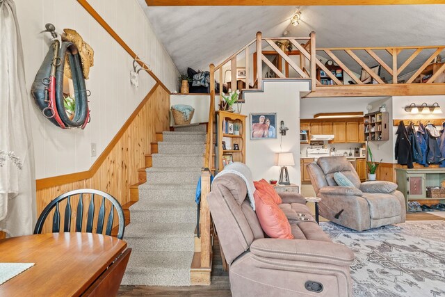 122 Wallace Rd, Northfield, VT 05663 - living room with vaulted ceiling, a wainscoted wall, wood finished floors, and stairway