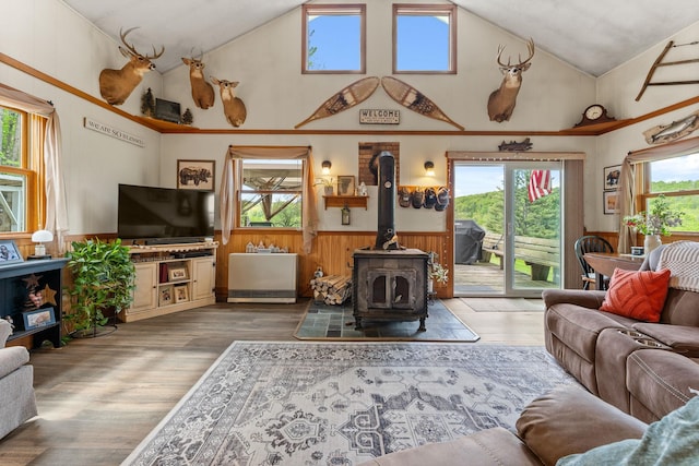 122 Wallace Rd, Northfield, VT 05663 - living area featuring wainscoting, a wood stove, high vaulted ceiling, healthy amount of natural light, and wood finished floors