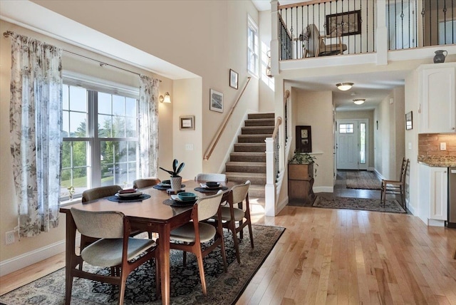 28A Black Walnut Ln Unit A, Jericho, VT 05465 - dining space featuring stairway, baseboards, plenty of natural light, light wood-style floors, and a towering ceiling