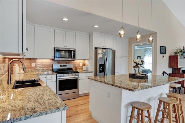 28A Black Walnut Ln Unit A, Jericho, VT 05465 - kitchen featuring appliances with stainless steel finishes, a sink, a kitchen breakfast bar, light stone counters, and recessed lighting