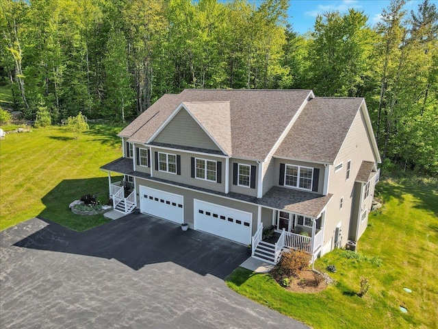 28A Black Walnut Ln Unit A, Jericho, VT 05465 - view of front of home featuring covered porch, an attached garage, asphalt driveway, a front yard, and roof with shingles