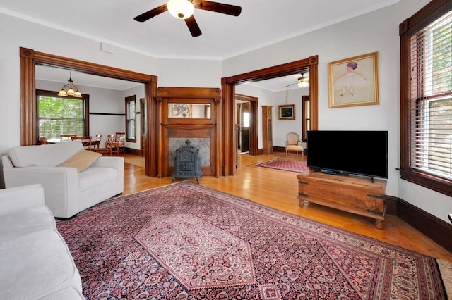 162 Sagamore St, Manchester, NH 03104 - living area featuring wood finished floors, a ceiling fan, a wood stove, ornamental molding, and baseboards