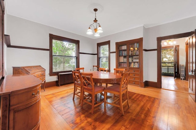 162 Sagamore St, Manchester, NH 03104 - dining room with radiator heating unit, light wood-type flooring, baseboards, and a chandelier