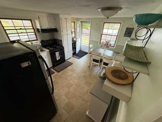 18 Caron Ave, Nashua, NH 03064 - kitchen featuring refrigerator, black gas range, under cabinet range hood, white cabinetry, and a sink