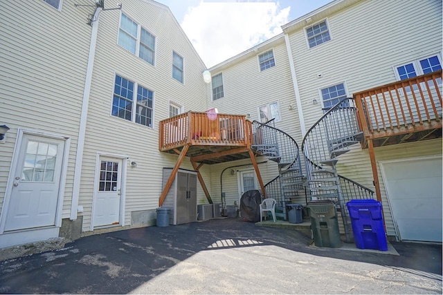 602 Silver St Unit 5, Manchester, NH 03103 - rear view of property with stairway, a deck, asphalt driveway, and an attached garage