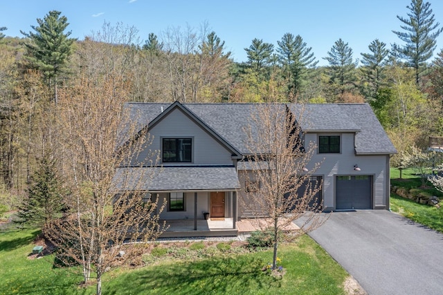 456 Thomas Ln, Stowe, VT 05672 - view of front of property with covered porch, asphalt driveway, an attached garage, roof with shingles, and a view of trees