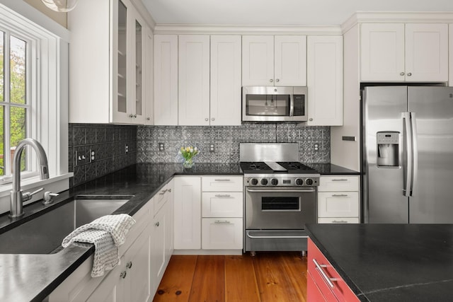 456 Thomas Ln, Stowe, VT 05672 - kitchen featuring appliances with stainless steel finishes, a sink, dark countertops, dark wood-style flooring, and glass insert cabinets