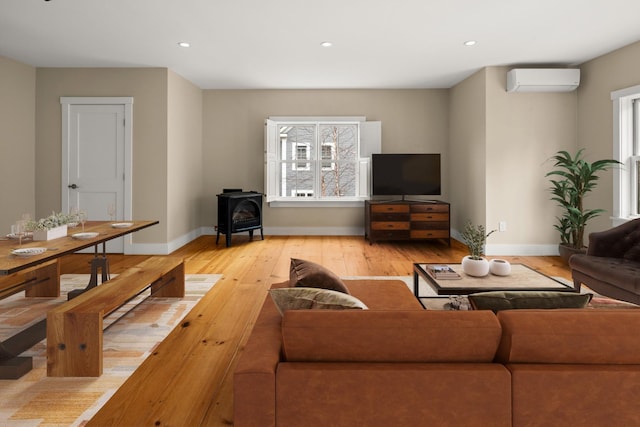 456 Thomas Ln, Stowe, VT 05672 - living room with a wood stove, a wall mounted AC, light wood-style flooring, baseboards, and recessed lighting