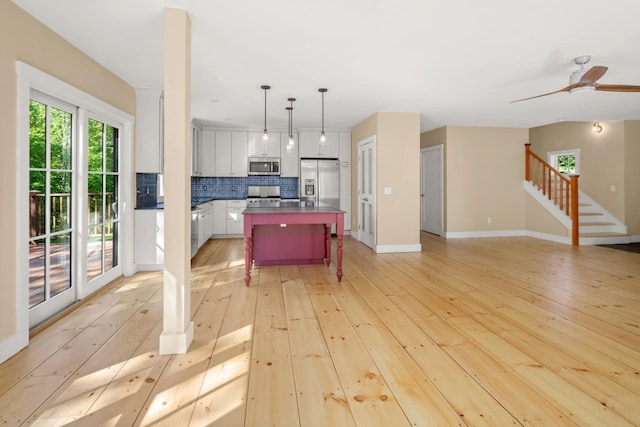 456 Thomas Ln, Stowe, VT 05672 - kitchen with stainless steel appliances, backsplash, a kitchen breakfast bar, light wood-style floors, and open floor plan