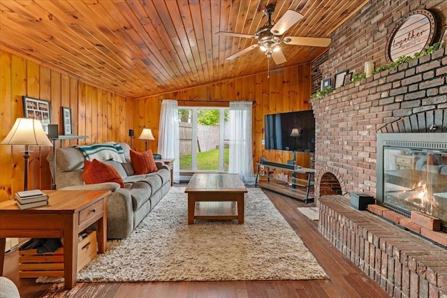 27 Eden St, Goffstown, NH 03102 - living area with lofted ceiling, ceiling fan, wood walls, a fireplace, and hardwood / wood-style floors