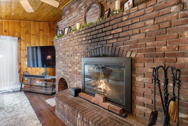 27 Eden St, Goffstown, NH 03102 - living area with a brick fireplace, hardwood / wood-style floors, wooden walls, brick wall, and wooden ceiling