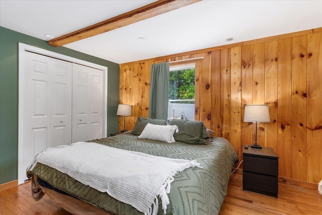 27 Eden St, Goffstown, NH 03102 - bedroom with beam ceiling, a closet, light wood-style floors, baseboards, and wood walls