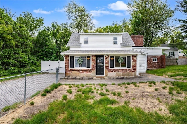 27 Eden St, Goffstown, NH 03102 - view of front of property featuring brick siding, roof with shingles, and a gate