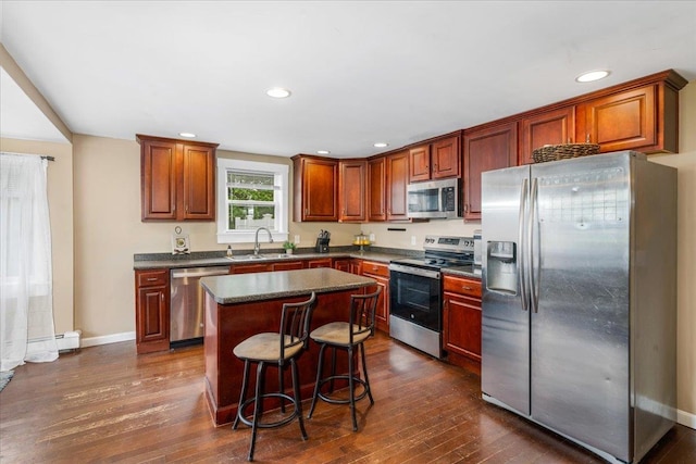 27 Eden St, Goffstown, NH 03102 - kitchen with appliances with stainless steel finishes, a sink, dark countertops, dark wood finished floors, and a center island