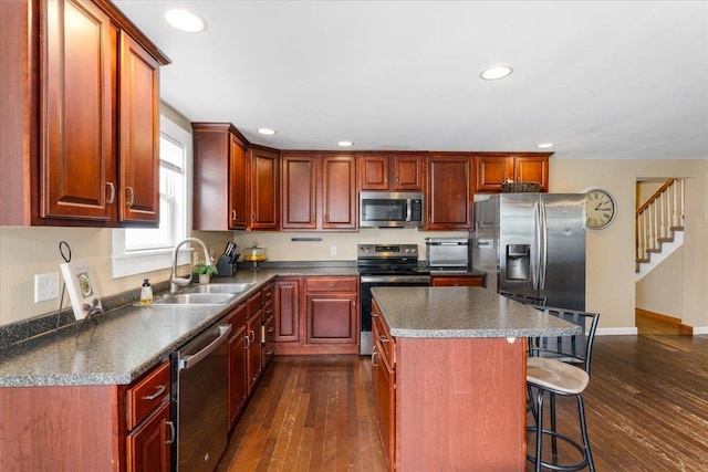 27 Eden St, Goffstown, NH 03102 - kitchen with appliances with stainless steel finishes, a sink, dark wood finished floors, a kitchen bar, and recessed lighting