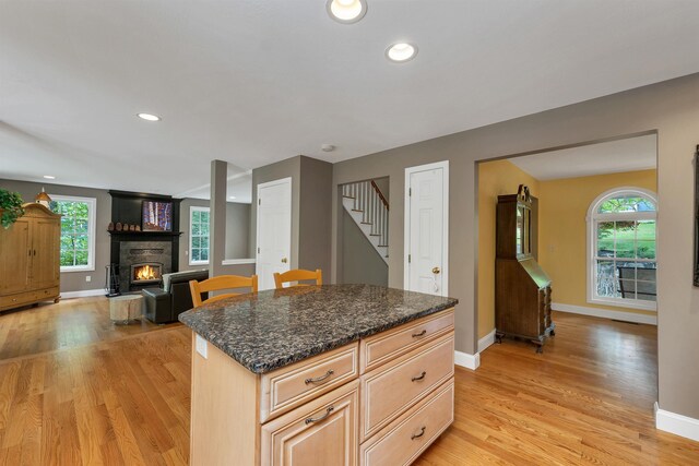 15 Largo Knl, Milford, NH 03055 - kitchen with a fireplace, light wood finished floors, baseboards, recessed lighting, and dark stone counters