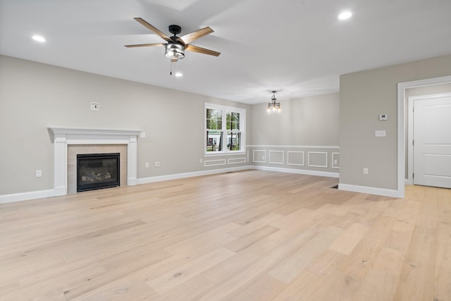 214 Pembroke St Unit A, Pembroke, NH 03275 - unfurnished living room featuring ceiling fan, a chandelier, a tiled fireplace, light wood-style floors, and recessed lighting