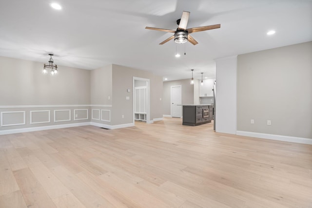 214 Pembroke St Unit A, Pembroke, NH 03275 - unfurnished living room featuring a ceiling fan, a chandelier, light wood-style flooring, recessed lighting, and baseboards