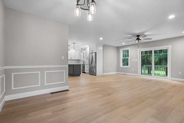 214 Pembroke St Unit A, Pembroke, NH 03275 - unfurnished living room with a chandelier, light wood-style floors, ceiling fan, recessed lighting, and baseboards