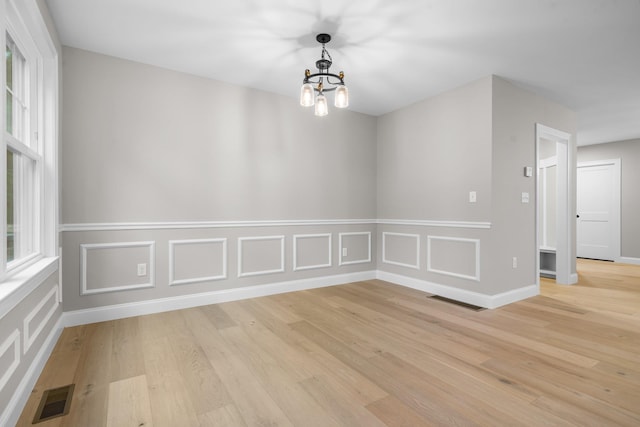 214 Pembroke St Unit A, Pembroke, NH 03275 - unfurnished dining area featuring a chandelier, light wood finished floors, and baseboards