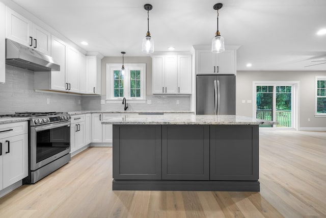 214 Pembroke St Unit A, Pembroke, NH 03275 - kitchen featuring stainless steel appliances, under cabinet range hood, a center island, light wood-type flooring, and a sink