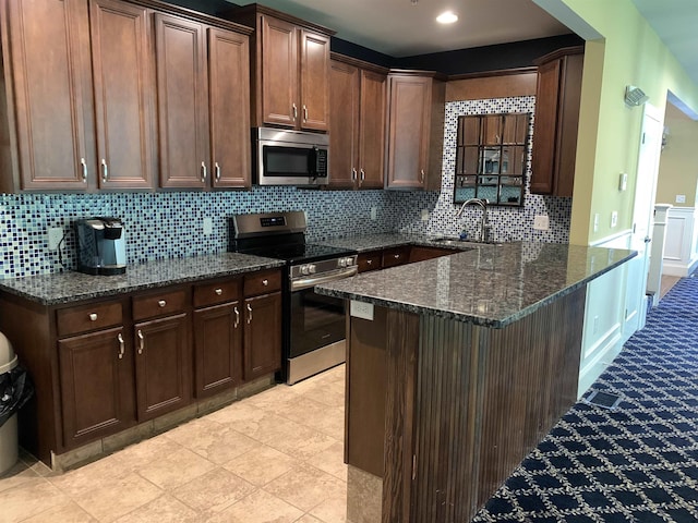 54 Cielo Dr, Dover, NH 03820 - kitchen with appliances with stainless steel finishes, dark stone counters, tasteful backsplash, a peninsula, and a sink
