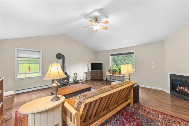 354 Falls Bridge Rd, Williamstown, VT 05679 - living area with a baseboard radiator, wood finished floors, a wood stove, ceiling fan, and healthy amount of natural light