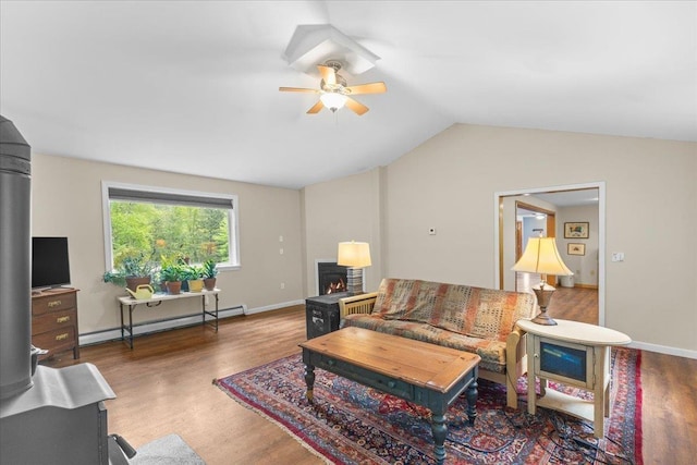 354 Falls Bridge Rd, Williamstown, VT 05679 - living room with a baseboard heating unit, ceiling fan, wood finished floors, vaulted ceiling, and a lit fireplace