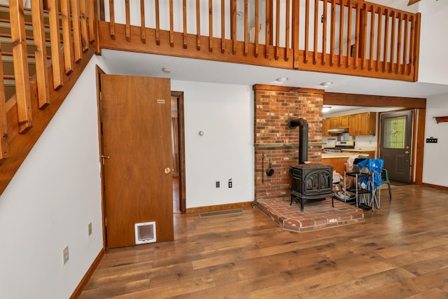 72 Mather Rd, Tamworth, NH 03886 - living room featuring wood finished floors, baseboards, a wood stove, and a high ceiling