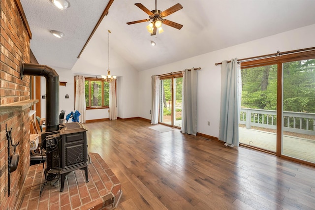 72 Mather Rd, Tamworth, NH 03886 - unfurnished living room featuring a wood stove, a ceiling fan, baseboards, wood finished floors, and high vaulted ceiling