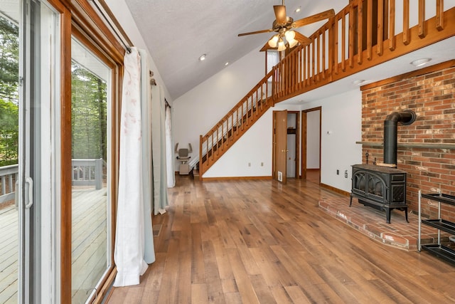72 Mather Rd, Tamworth, NH 03886 - entrance foyer featuring a wood stove, hardwood / wood-style floors, a ceiling fan, stairs, and high vaulted ceiling