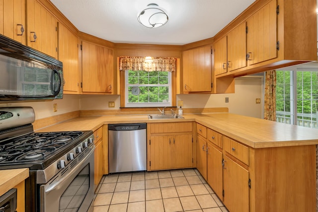 1 Pepperell Cir, Nashua, NH 03062 - kitchen featuring appliances with stainless steel finishes, a sink, a peninsula, light tile patterned floors, and light countertops