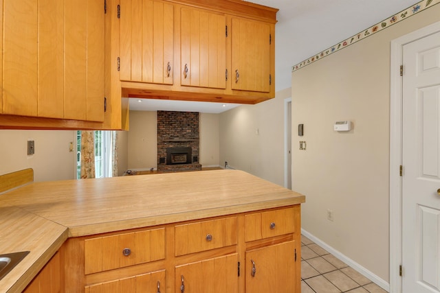 1 Pepperell Cir, Nashua, NH 03062 - kitchen featuring light tile patterned flooring, light countertops, a fireplace, and a peninsula