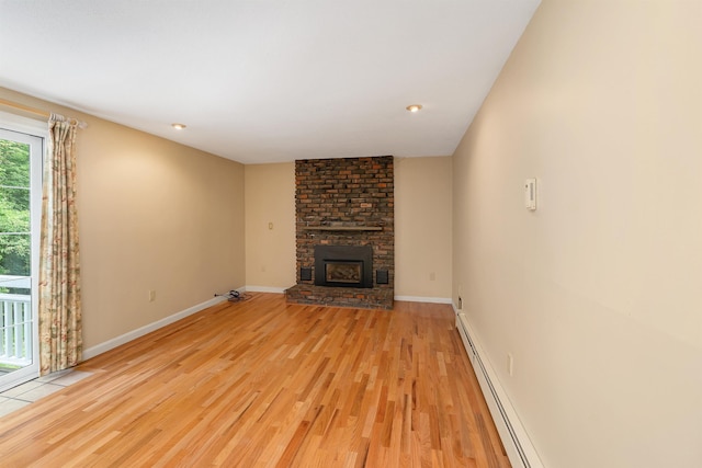 1 Pepperell Cir, Nashua, NH 03062 - unfurnished living room featuring light wood-style floors, a brick fireplace, baseboards, and a baseboard radiator