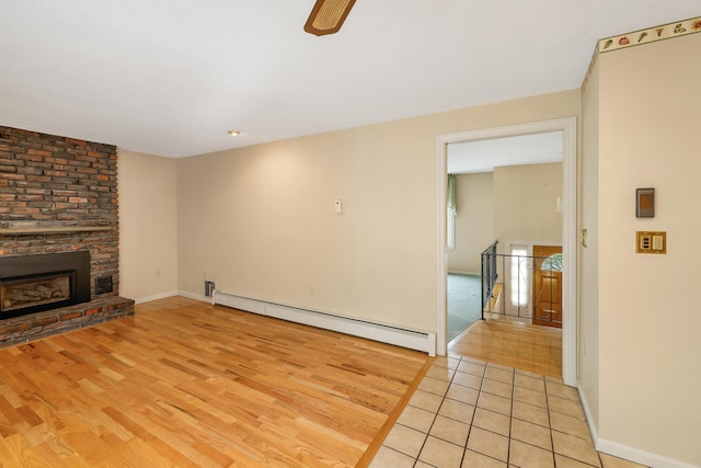 1 Pepperell Cir, Nashua, NH 03062 - unfurnished living room featuring a baseboard heating unit, light wood finished floors, a fireplace, baseboards, and ceiling fan