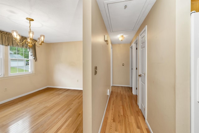 1 Pepperell Cir, Nashua, NH 03062 - hall featuring attic access, light wood finished floors, a chandelier, and baseboards