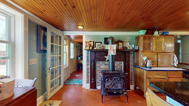 358 S Main St, Whiting, VT 05778 - kitchen with french doors, a wood stove, crown molding, brown cabinetry, and wooden ceiling