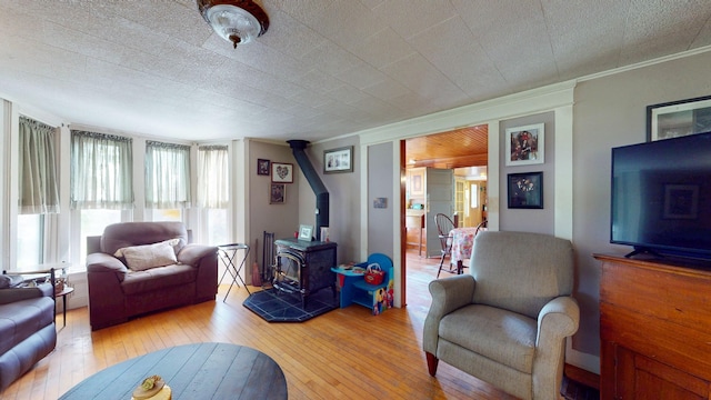 358 S Main St, Whiting, VT 05778 - living area featuring a wood stove, plenty of natural light, light wood-type flooring, and ornamental molding