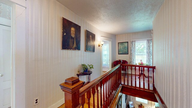 358 S Main St, Whiting, VT 05778 - hall featuring a textured ceiling, an upstairs landing, wallpapered walls, and baseboards