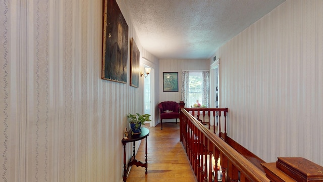 358 S Main St, Whiting, VT 05778 - corridor featuring a textured ceiling, light wood-type flooring, and an upstairs landing