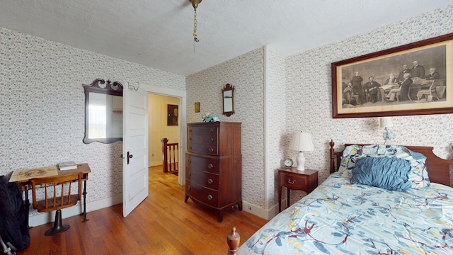 358 S Main St, Whiting, VT 05778 - bedroom with wood finished floors, wallpapered walls, baseboards, and a textured ceiling