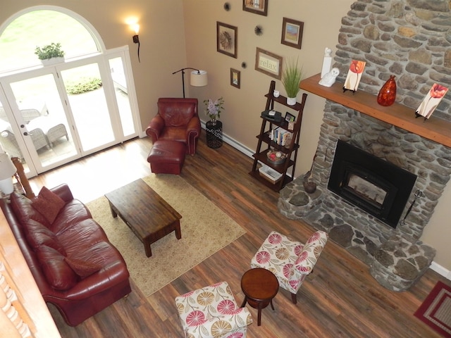 1782 Old Creamery Rd, Williston, VT 05495 - living room featuring wood finished floors, baseboards, a stone fireplace, and a baseboard radiator