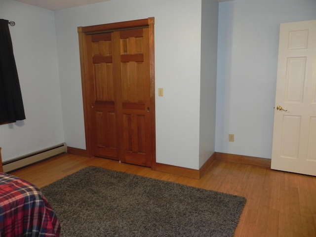 1782 Old Creamery Rd, Williston, VT 05495 - bedroom featuring a baseboard radiator, light wood-style flooring, and baseboards