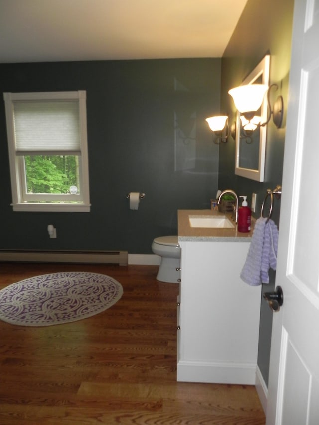 1782 Old Creamery Rd, Williston, VT 05495 - bathroom featuring baseboard heating, vanity, wood finished floors, toilet, and baseboards